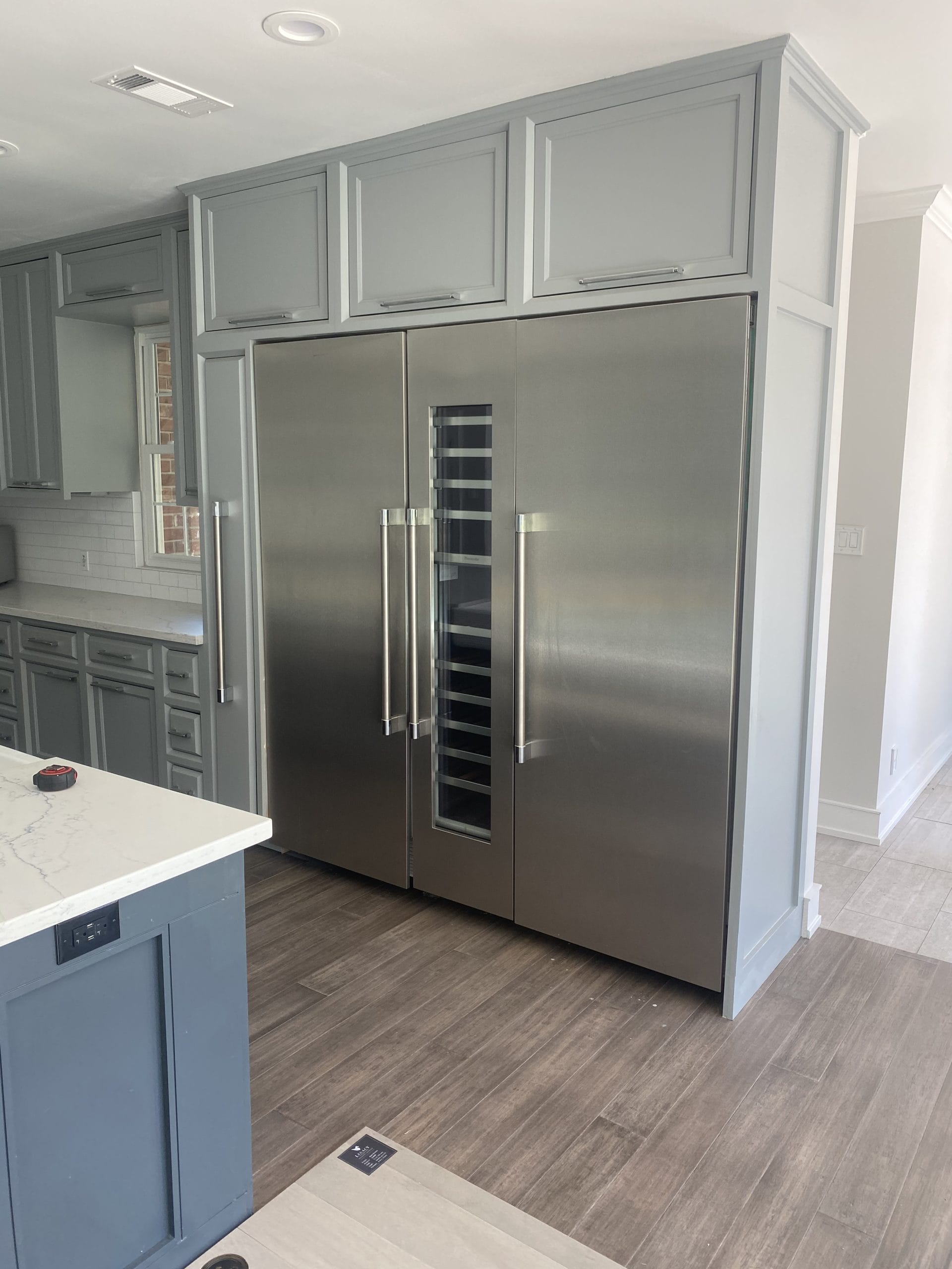 Completed custom surround integrating the refrigeration appliances and wine cooler, full project view 6