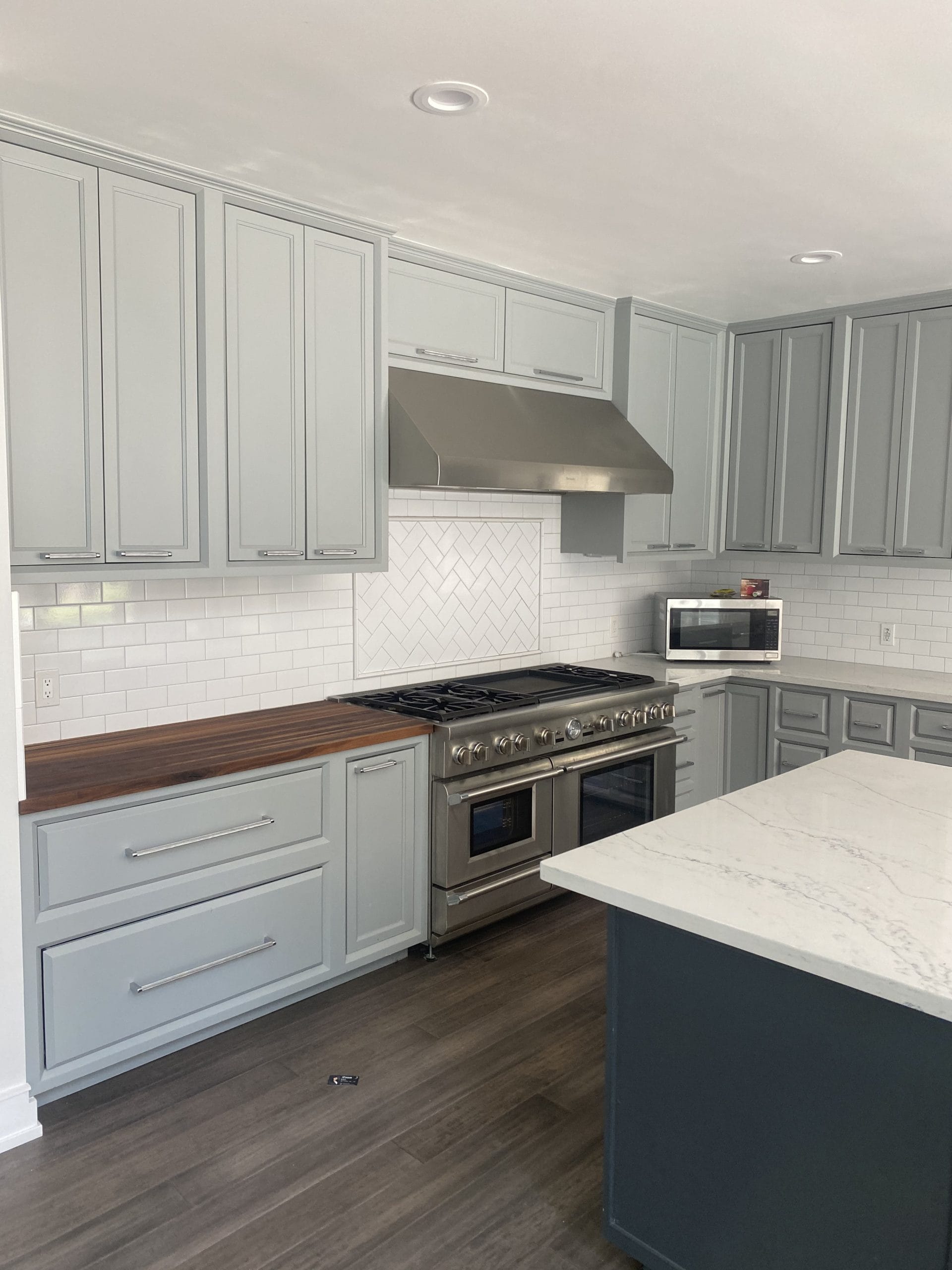 Finished kitchen with light-gray Shaker cabinetry and dark island, full project view 8