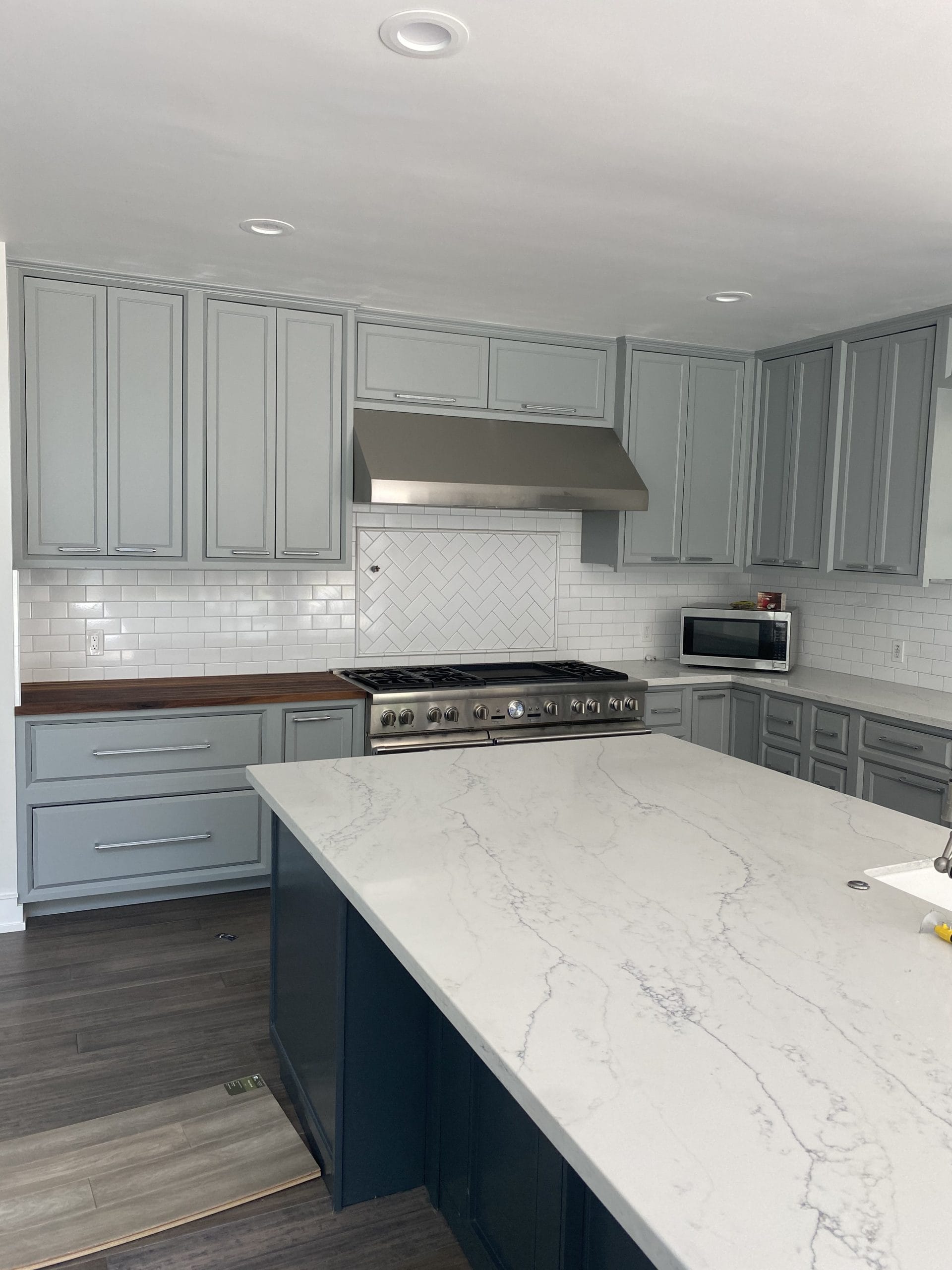 Completed Shaker cabinetry surrounding the professional range and hood, full project view 7